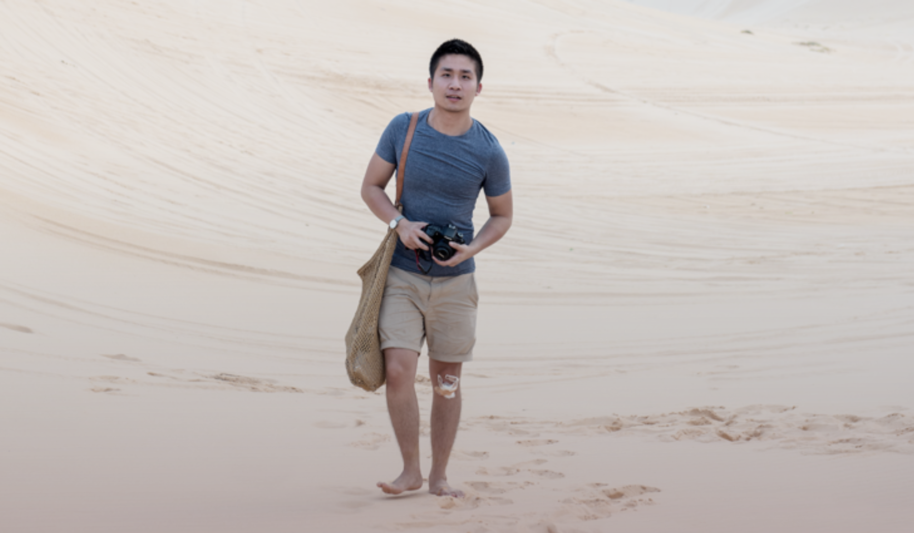 Supplied: Jaron Soh walking in sand, wearing blue tshirt and beige shorts